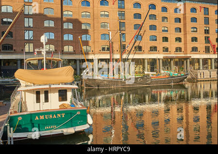 Boats reflected in the waters of regenerated St Katherines Dock in London. Stock Photo