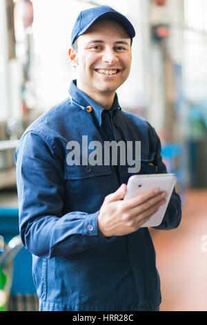 Mechanic using a tablet in his garage Stock Photo