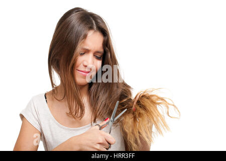 Young woman looking at split ends. Damaged long hair Stock Photo