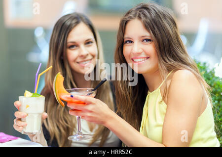 Portrait of two friends drinking a cocktail Stock Photo