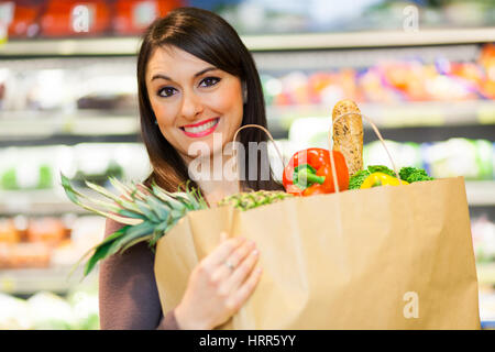 Smiling woman shopping in a supermarket Stock Photo