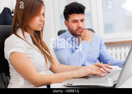 Business people using a laptop computer in their office Stock Photo
