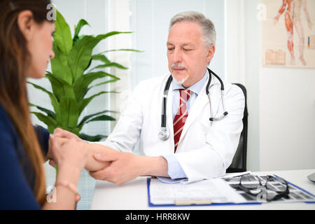 Doctor checking a patient's arm Stock Photo