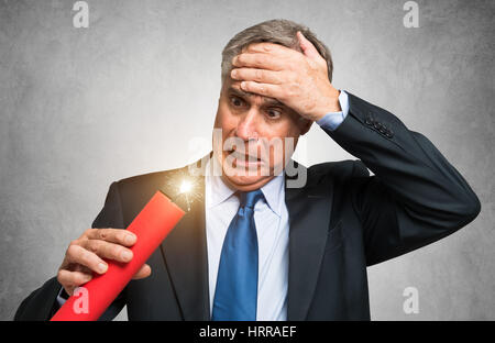 Businessman holding a dynamite stick, financial risk concept Stock Photo