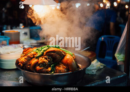 Hot pork cools down at the Saturday Night Market stall in Chiang Mai, Thailand. Stock Photo