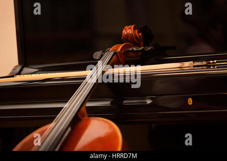 Classical music concept: violin leaning on a piano Stock Photo