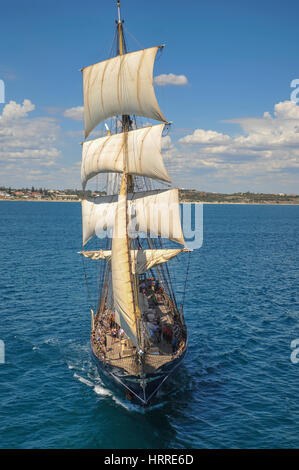 Aerial view of sailing ship, with coast in background Stock Photo