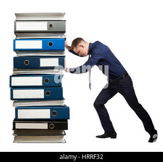 Young businessman is pushing the huge pile of folders with documents. Yearly corporate report. Isolated on white. Stock Photo