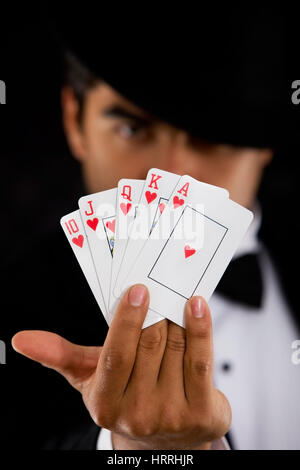 elegant man with Royal Flush Poker Hand - focus on cards Stock Photo