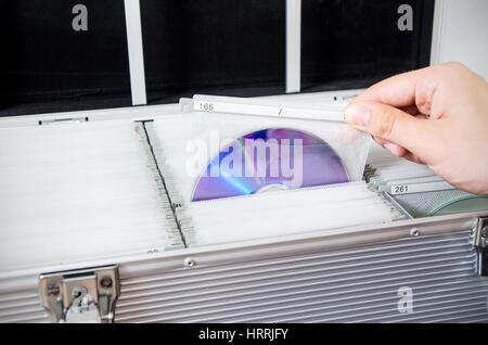 Hand pulls disc from aluminum carrying case Stock Photo