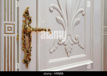 White door with golden antique lock and doorhandle close up view Stock Photo