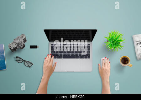 Office desk with laptop computer. Woman work on computer with blank screen for design presentation. Top view of clean tidy desk. Stock Photo