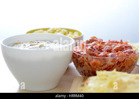 Colorful salads in ceramic bowls and salt cake with cheese and red paprika Stock Photo