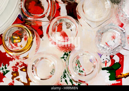 Washed glasses turned upside down and other various dishes on home table Stock Photo
