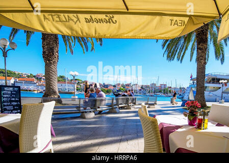 TROGIR, CROATIA - SEPTEMBER 17: Croatian restaurant by the seafront in Trogir town with a view of the harbor and promenade on a sunny day on September Stock Photo