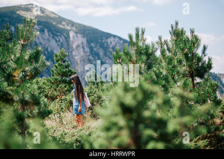 long hair woman travel in spruce forest with picturesque view in Montenegro, Durmitor Stock Photo