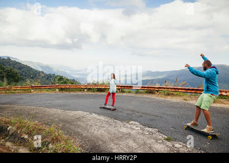 hipster couple longboarding extremely in tropcis travel vacation in Asia Stock Photo