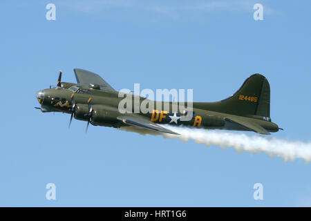 The UK's, and now also Europe's only airworthy B-17 with a flypast at a Rougham Airshow in Suffolk. The smoke is simulated battle damage. Stock Photo