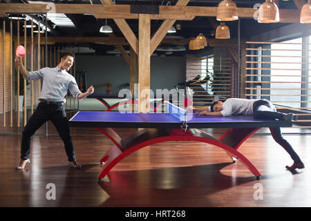 Young businessmen playing ping pong Stock Photo