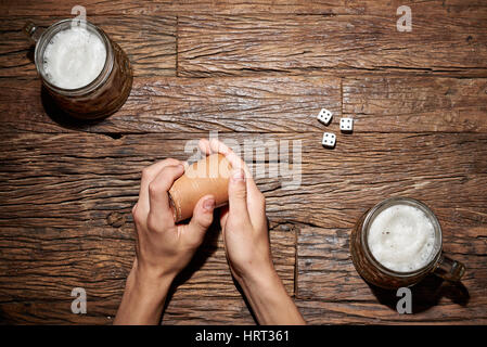 Playing dice game on an old wooden table with beer mug Stock Photo