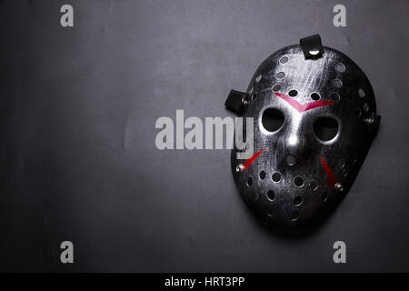 Hockey mask of serial killer with bloody strips isolated on black background. Murder horror Stock Photo