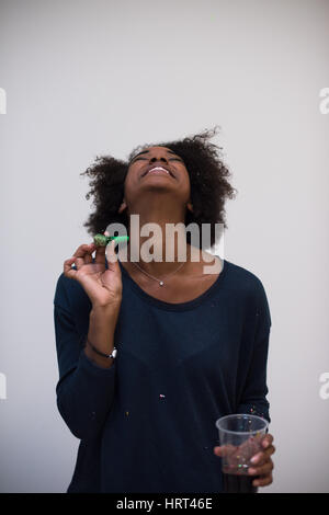 Young African American woman with whistle and soccer ball on green ...