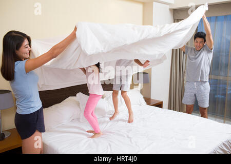 Cheerful young family on a bed Stock Photo