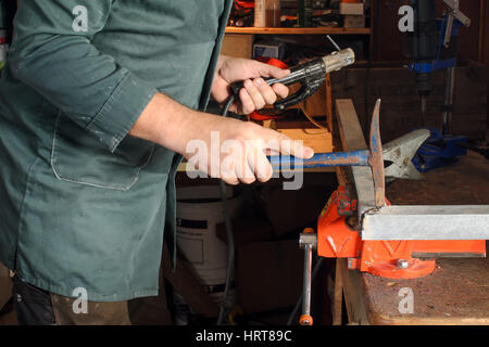 Man is using a hammer at welding work Stock Photo