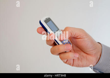 Male hand holding a mobile phone. Close view. Stock Photo