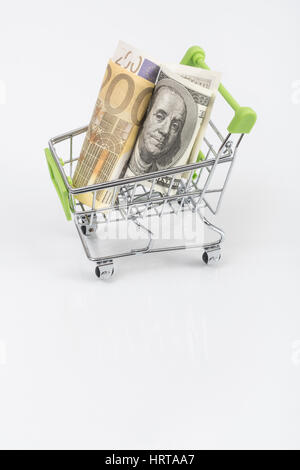 US100 Dollar and 200 Euro banknotes in shopping cart / trolley. Metaphor for exchange rates, free trade, trade war, globalism. Stock Photo