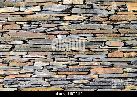 Schist stones on a house piled to a wall Stock Photo