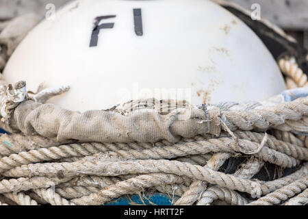 white buoy with old rope wrapped around it, F1 Stock Photo