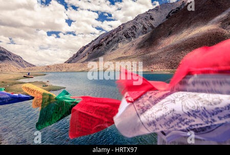 Buddhist flags waving in the wind over a small lake in Ladakh, Kashmir, India Stock Photo