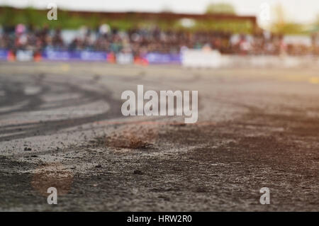 Closeup of burn tire on drift racing competion. Ash burn tire on asphalt track Stock Photo