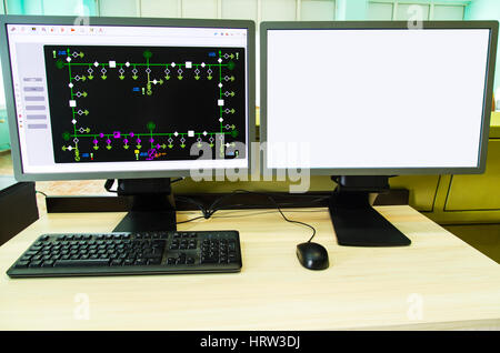 Computers and monitors with schematic diagram for supervisory, control and data acquisition in modern electrical control room Stock Photo