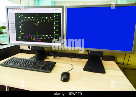 Computers and monitors with schematic diagram for supervisory, control and data acquisition in modern electrical control room Stock Photo
