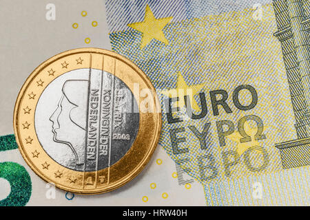 a 1 euro coin from the Netherlands on a 5 euro banknote Stock Photo