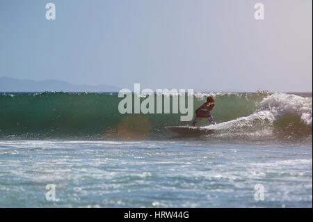Man surfing on pacific ocean wave on sunny day. Extreme sport surf. One surfer on blue sea wave water Stock Photo