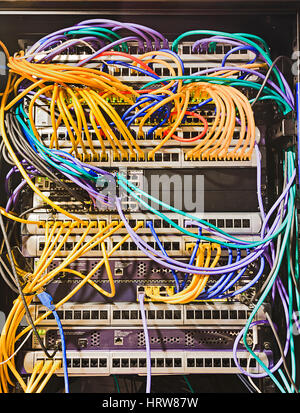 Computer data centre rack with patch panels and connected plugged patch cords as a backbone of IT infrastructure and modern technology. Stock Photo