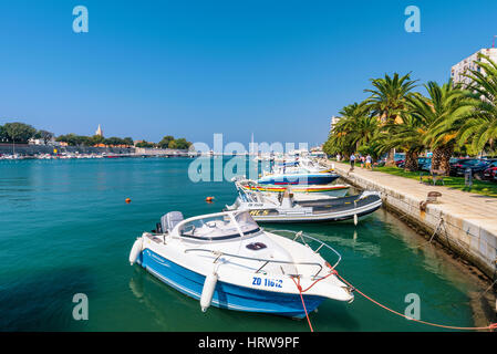ZADAR, CROATIA - SEPTEMBER 14: Harbor in downtown Zadar with palm trees and walking path on a hot sunny day on September 14th, 2016 in Zadar Stock Photo