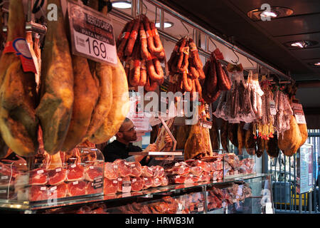 Barcelona, Spain - March 02, 2016: Market stall at Mercat de Sant Josep de la Boqueria offering a choice of Jamon Iberico cured ham and Chorizo sausag Stock Photo