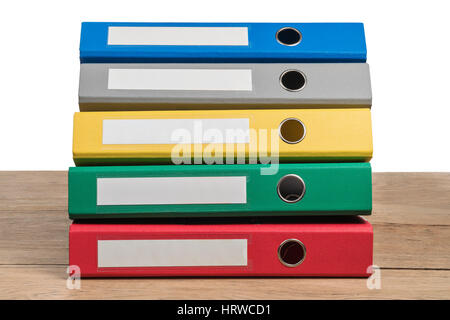 Several multi-colored office folders lying in a stack on a wooden table isolated on white background Stock Photo