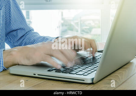 Close-up man typing on computer laptop in blurred motion. Stock Photo