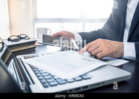Business, office concept. Working process, Man using digital tablet with financial document. Stock Photo