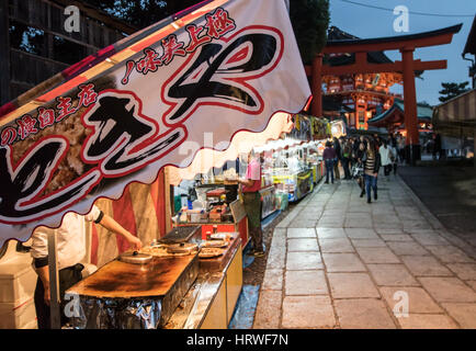 Line of food kiosks in the street beside a Buddhist temple Inari Shrine, Kyoto, Japan Stock Photo