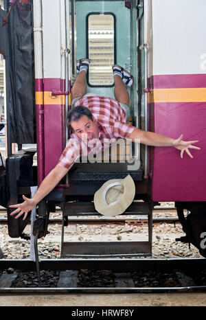 Tourist falls out of the open doors of the train on the platform. Passenger falls out of the train on railway station Stock Photo