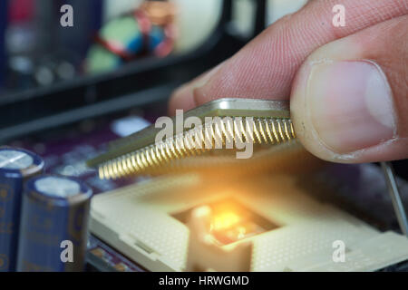 Selective focus of plug in CPU microprocessor to motherboard socket and light, mainboard computer as technology and central concept. Stock Photo