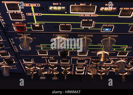 Detailed view of the upper set of switches in a large airliner. Selective focus. Low Light from a plane control cockpit in the dark vintage, detail on Stock Photo