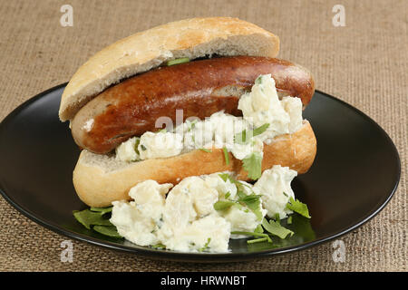 food fresh bratwurst in a crusty bun with potato salad Stock Photo