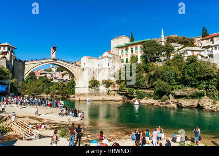 MOSTAR, BOSNIA AND HERZEGOVINA - SEPTEMBER 23: View of Stari Most bridge and Mostar old town from a beach where people come to view the famous red bul Stock Photo